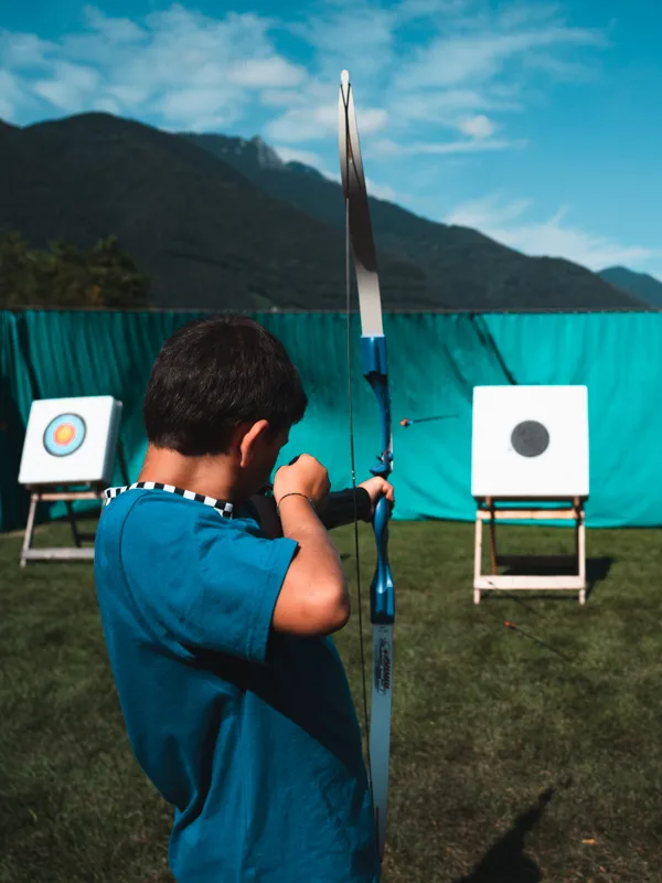 Ragazzo al tiro con l'arco, con i bersagli sul prato