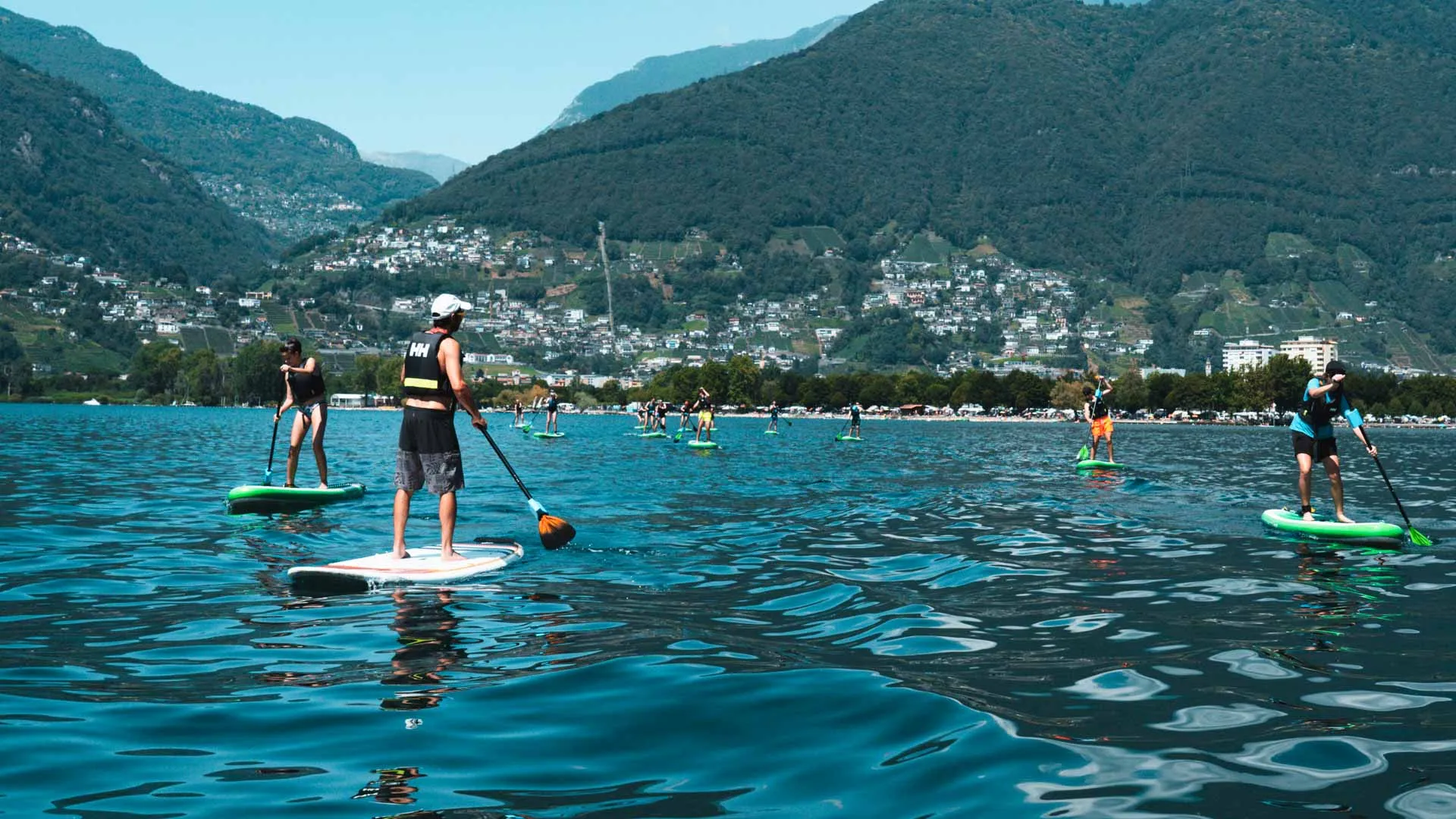 Lezione di stand up paddle sul Lago Maggiore, con le montagne sullo sfondo